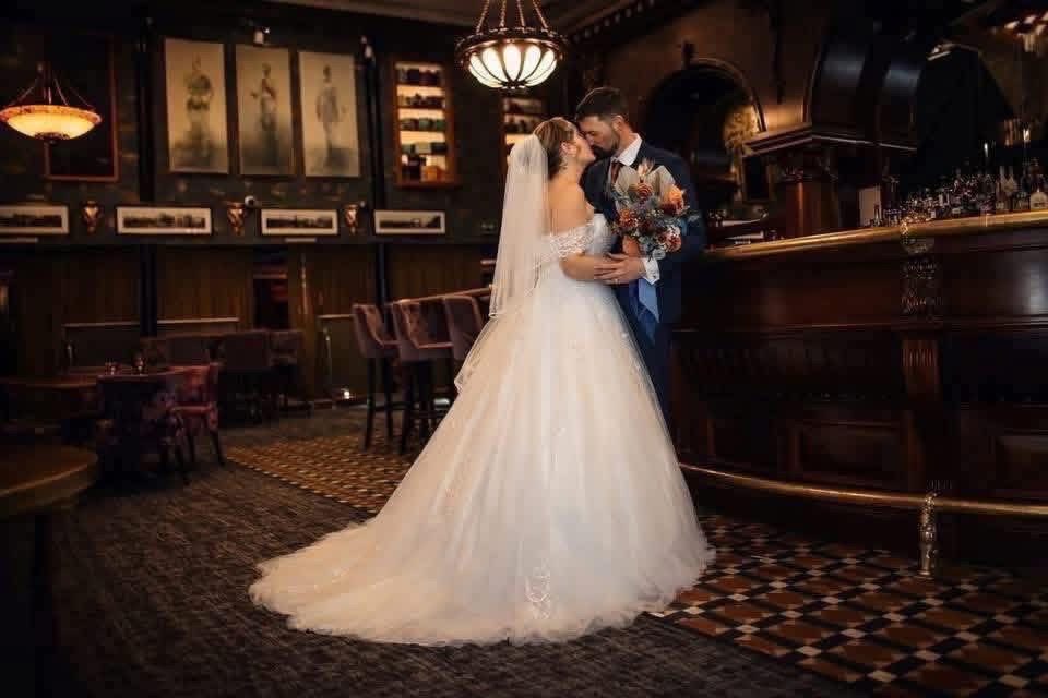 A wedding couple sharing a quiet moment inside a dark elegant venue