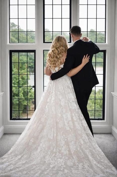 Bride and groom viewed from behind by a window