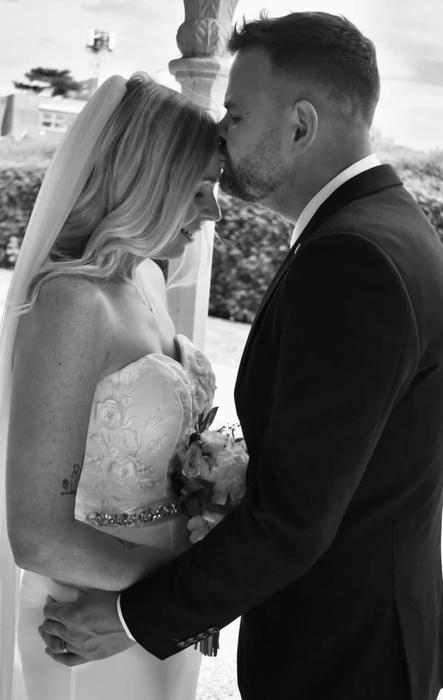Wedding couple smiling on a white sofa